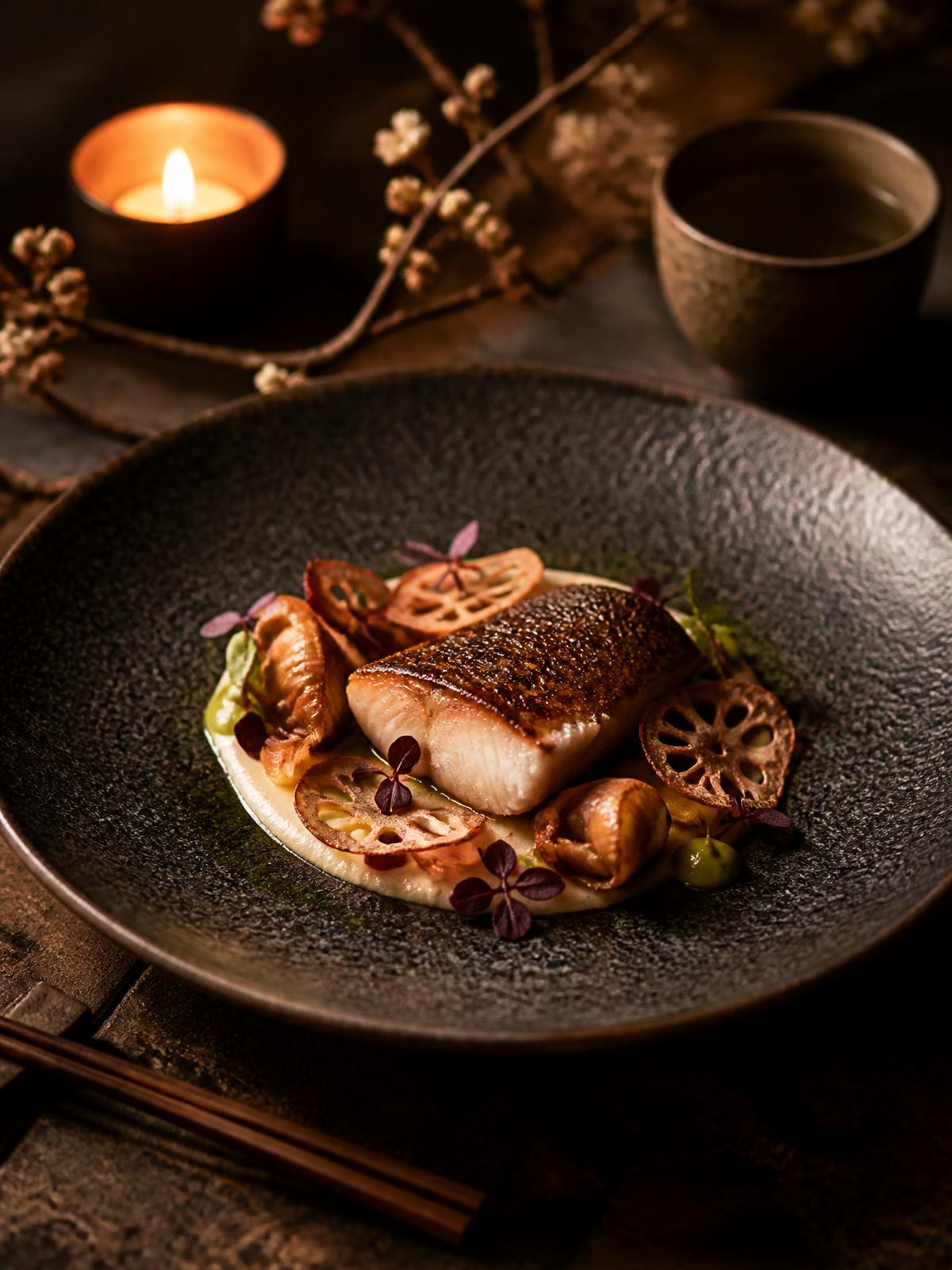 Gerecht van restaurant WestSingel op donker keramiek bij kaarslicht